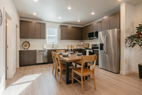A kitchen with a table and chairs in the middle of the room.