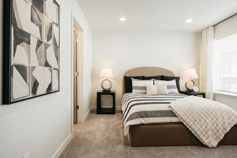 A bedroom with a large bed and a painting on the wall.
