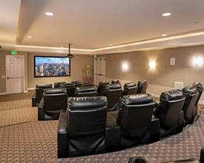 Room filled with leather chairs and a flat screen tv