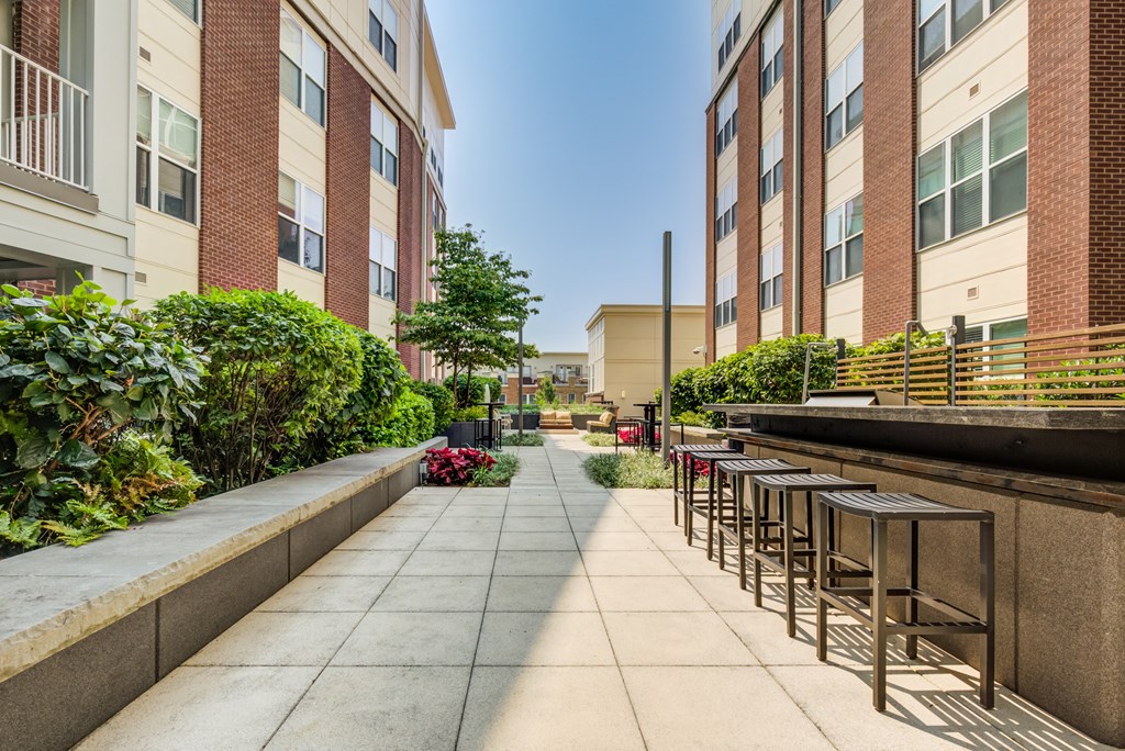 an outdoor patio with stools and plants
