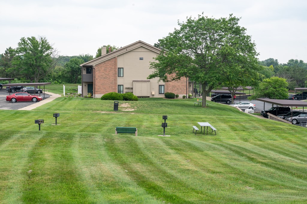 a grassy area with a building in the background
