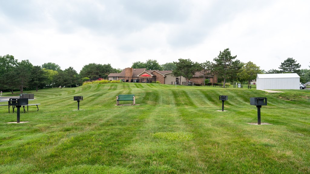 a grassy field with a house in the background