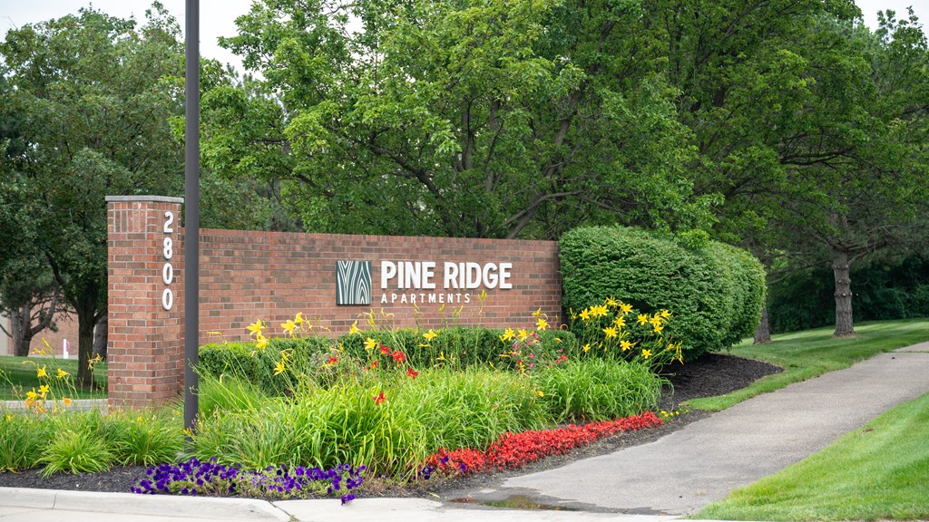 a brick wall with a sign that says pine ridge apartments