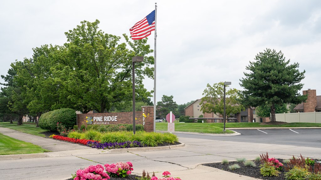 a flagpole with an american flag in front of a building with a sign that says