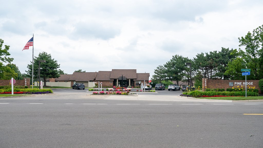 a parking lot with a building in the background and an american flag in the foreground