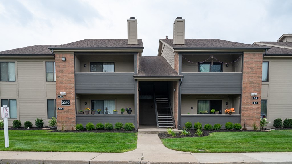 a home with a gray exterior and a green lawn