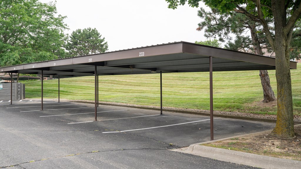 a covered parking lot with a grassy field in the background