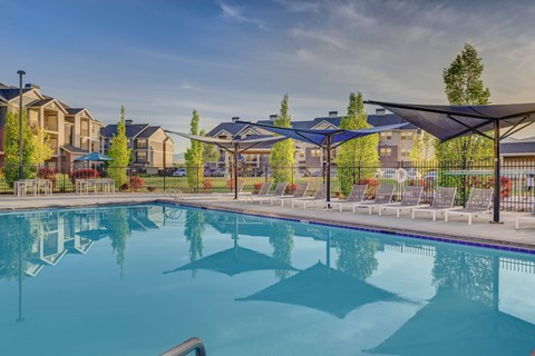 A large swimming pool in front of a resort.