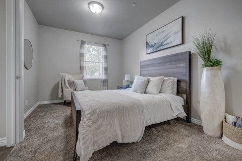 A bedroom with a large bed and a smaller bed in the background.