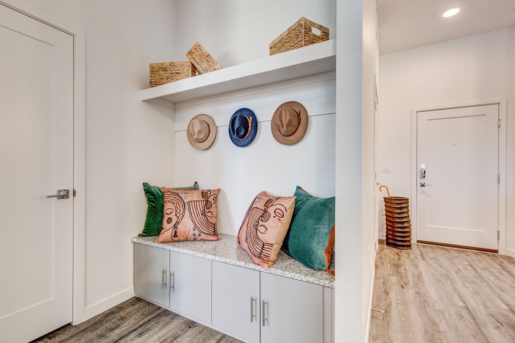 Built-in mudroom area with cabinets and seating space