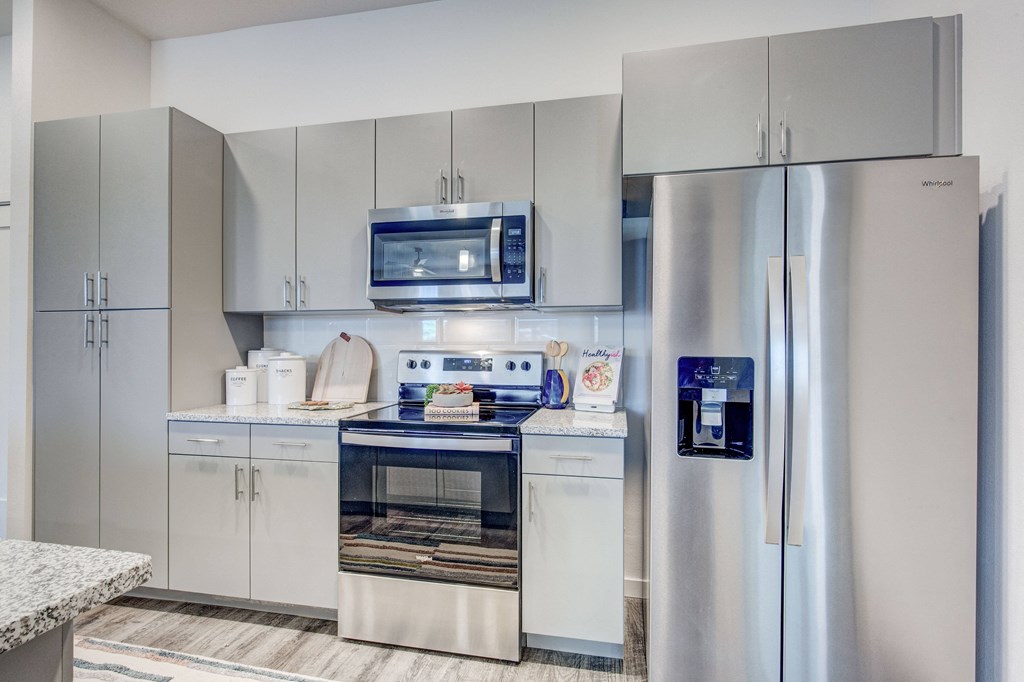 Kitchen with microwave, side-by-side refrigerator with water and ice dispenser, stove and oven