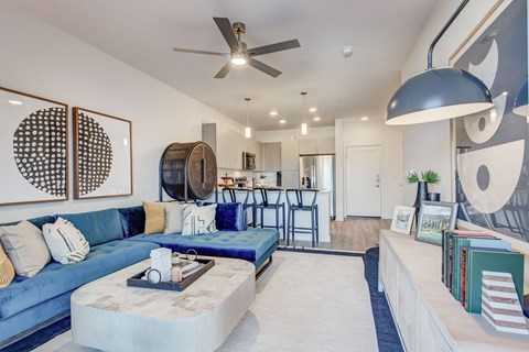 a living room with a blue couch and a ceiling fan