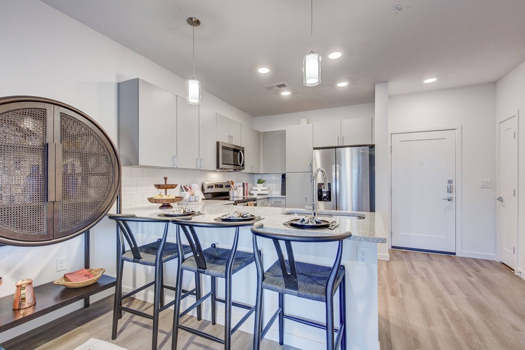 Model kitchen bar top with pendant lighting and bar stools