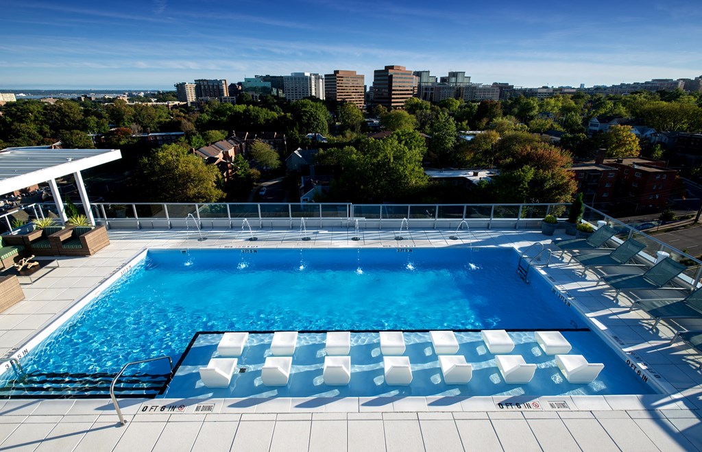 an aerial view of a large swimming pool with a cityscape in the background