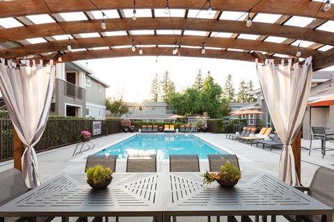 Dog-Friendly Apartments in Pleasanton, CA - Civic Square - Pool with a Wooden Cabana, Seating Area, and Lounge Chairs