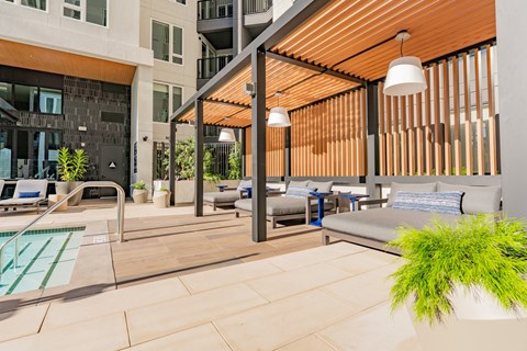 A modern outdoor seating area with a pool and lounge chairs.