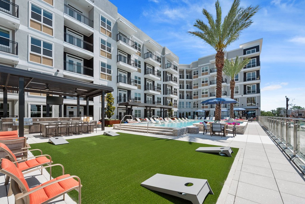 A large white building with a pool and palm tree.