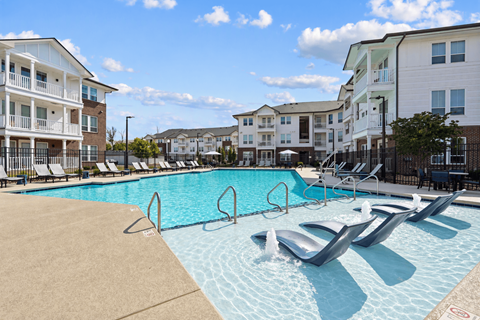 A swimming pool with a slide in front of apartment buildings.