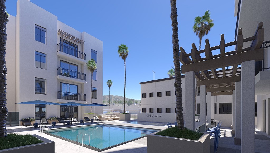 a swimming pool in front of a building with palm trees