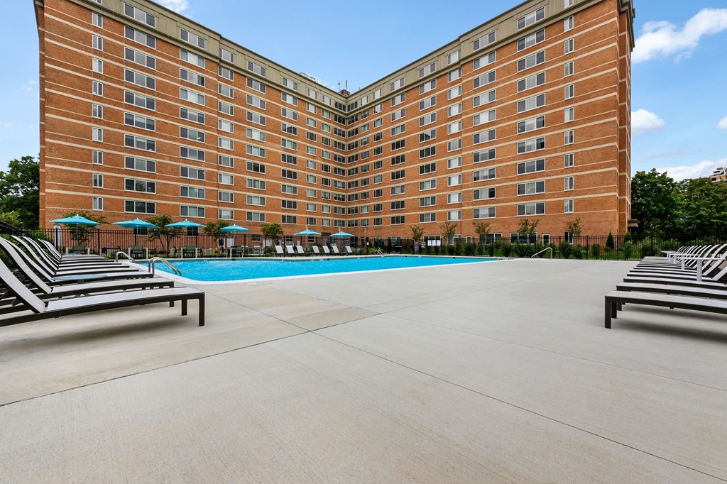 a swimming pool in front of a large apartment building