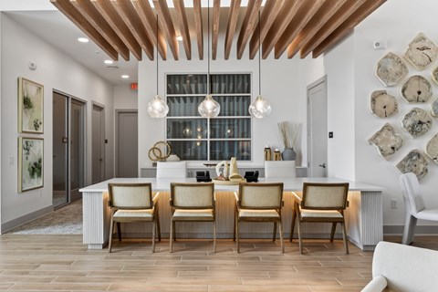 A kitchen with a white counter and chairs.