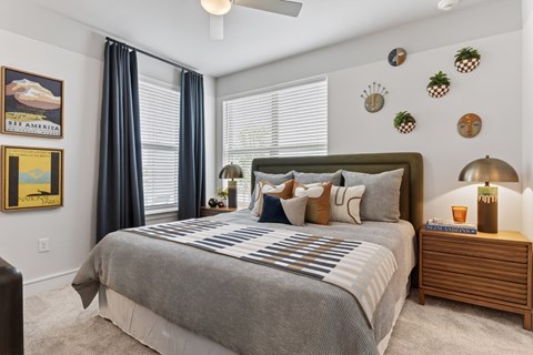 A bedroom with a large bed and a painting of a beach scene on the wall.