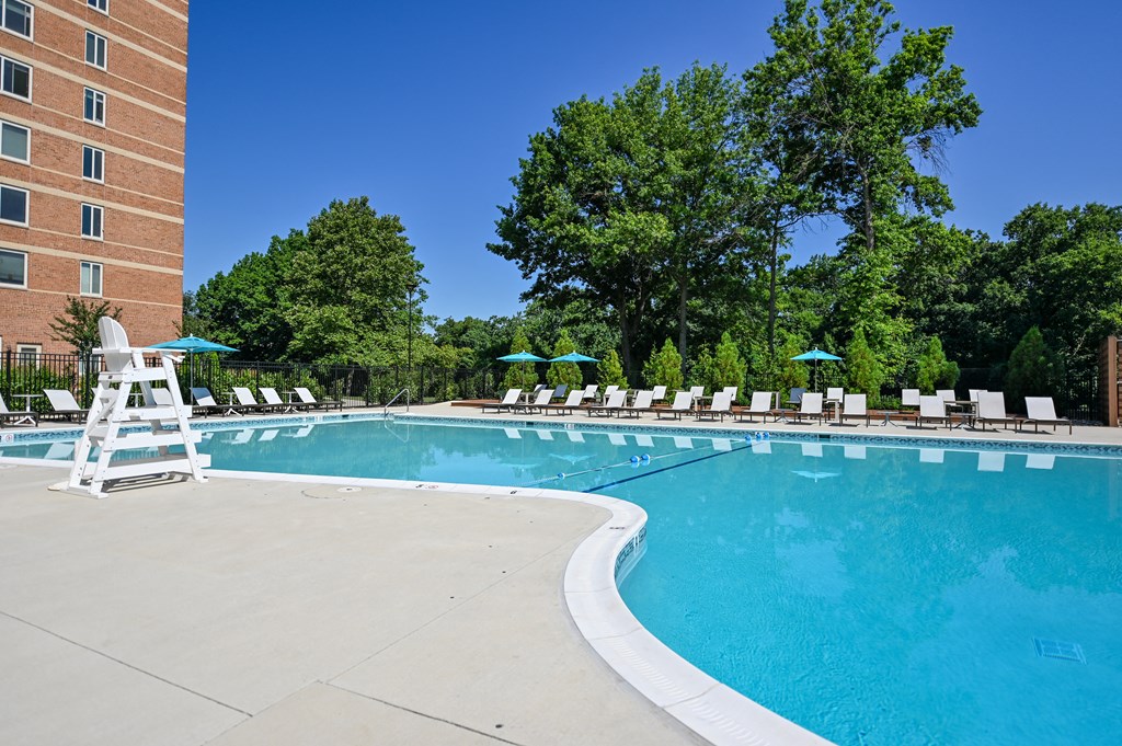 a swimming pool with chairs and a hotel building