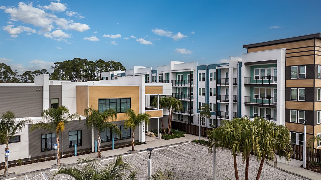 a row of apartment buildings with palm trees in front of them