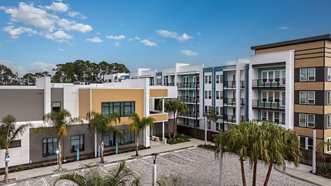 a row of apartment buildings with palm trees in front of them