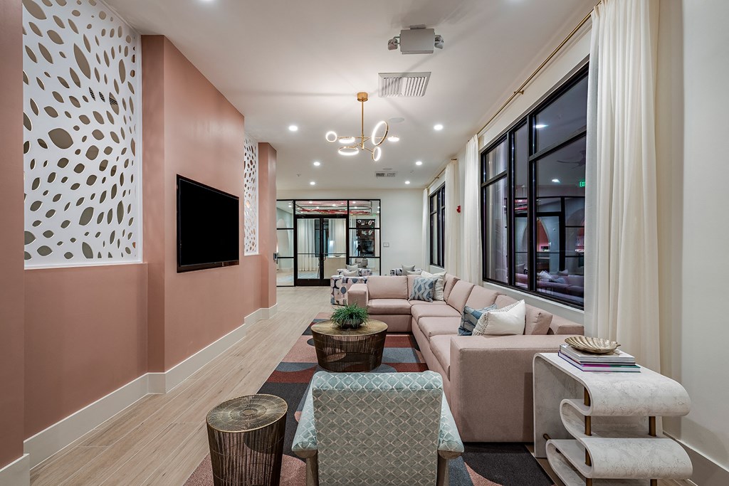 a living room with pink walls and furniture and a large window