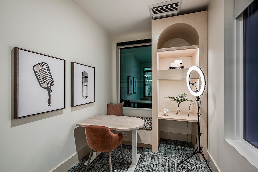 a small room with a desk and a mirror and a bathroom