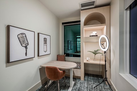 a small room with a desk and a mirror and a bathroom