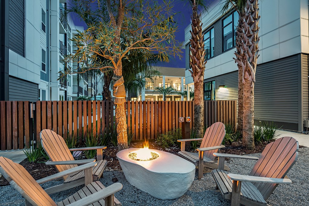 a fire pit in a courtyard with chairs and a table