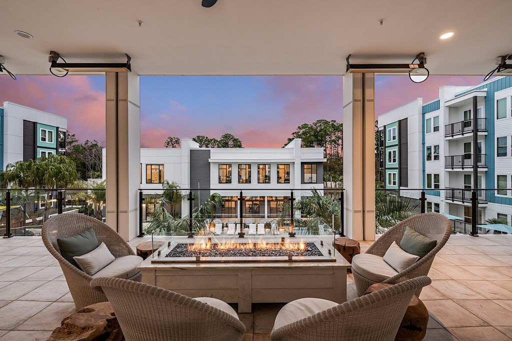 an outdoor patio with a fire pit and chairs