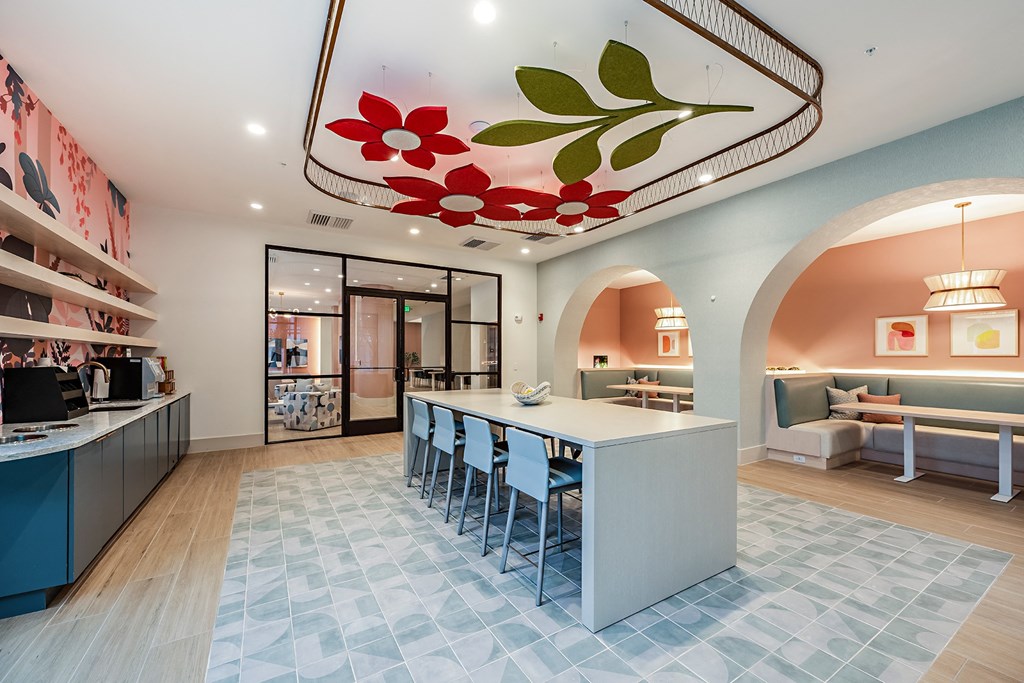 a kitchen with a long counter and chairs in a lobby