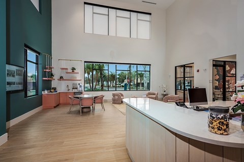 a kitchen and living room with a large window and a desk with a computer