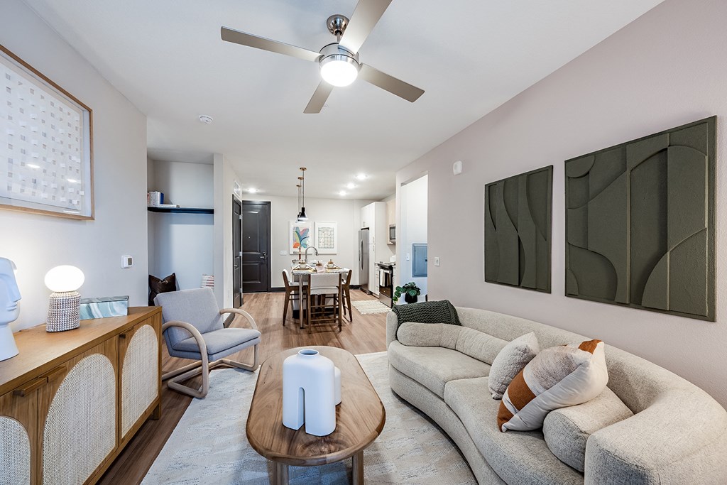 a living room with couches and chairs and a ceiling fan
