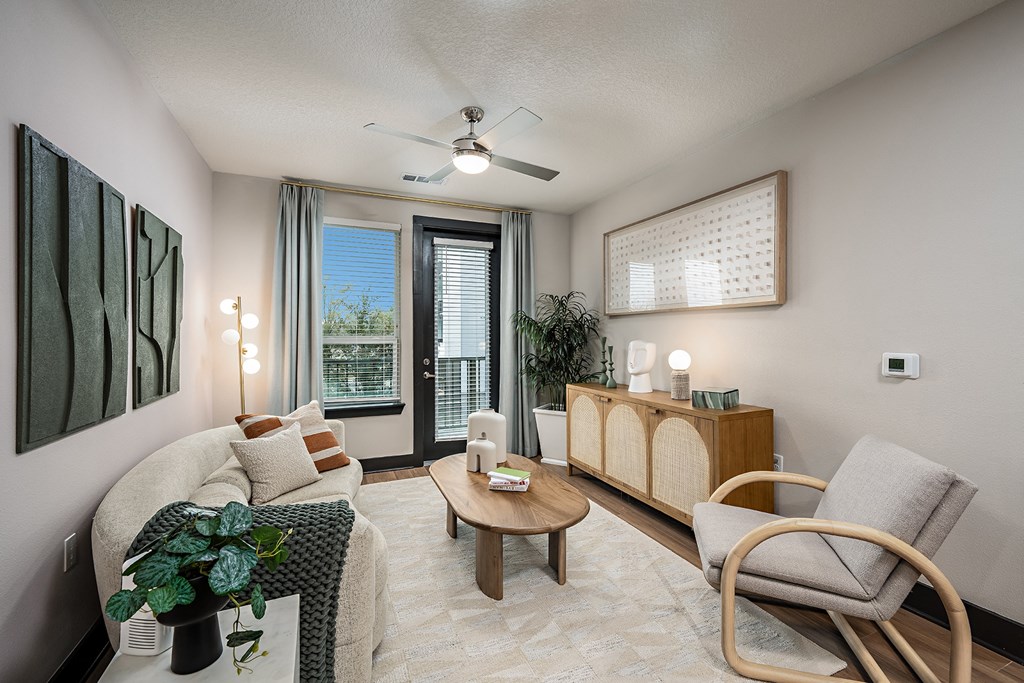 an open living room with a couch and chairs and a ceiling fan