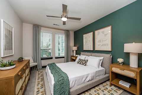 a bedroom with a large bed and a ceiling fan