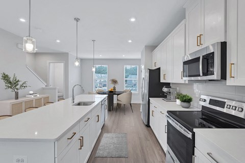 an open kitchen and dining room with white cabinets and black appliances