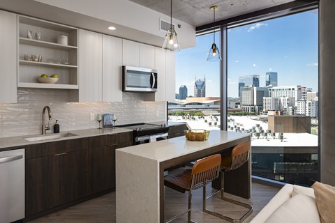 A modern kitchen with a view of the city skyline.