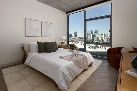 A bedroom with a large bed and a view of the city.