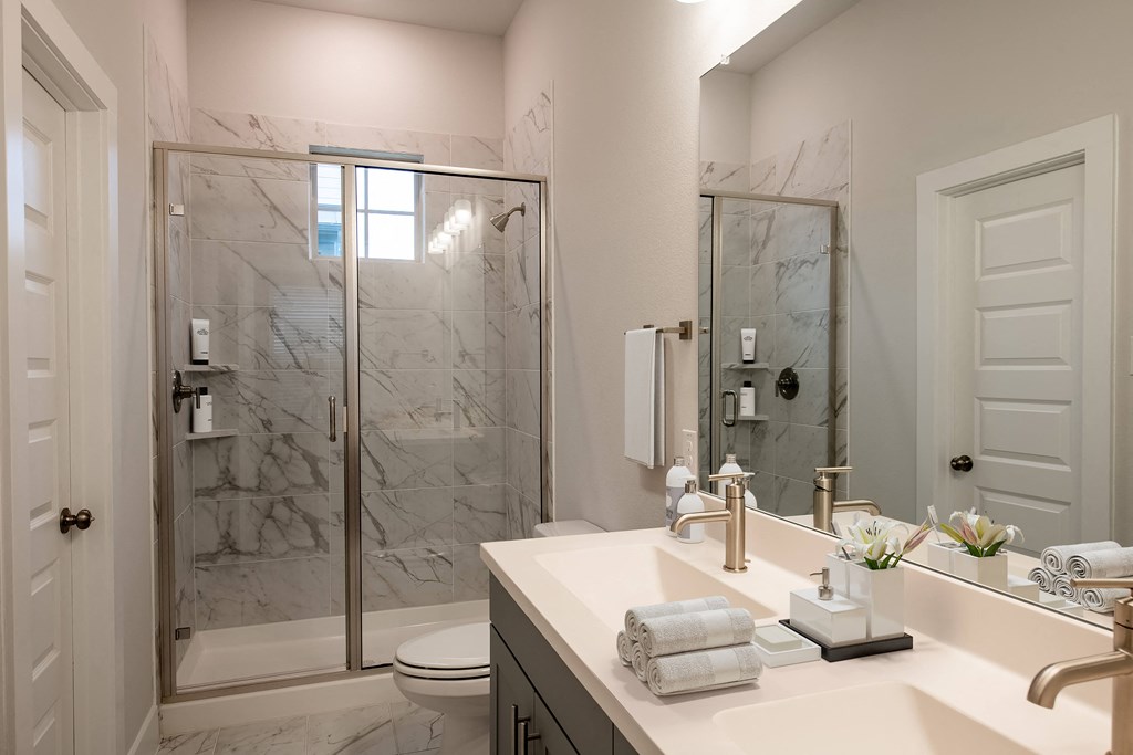 a bathroom with a shower and a sink and a mirror