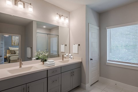 a white bathroom with two sinks and a large mirror
