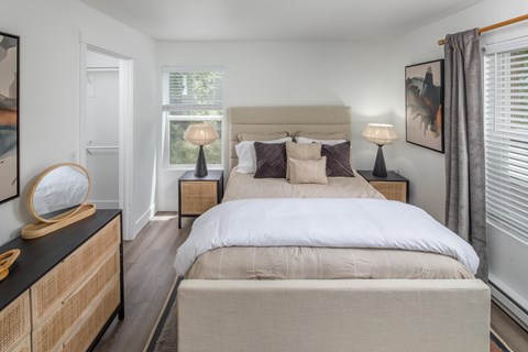 A bedroom with a large bed and a wooden dresser.