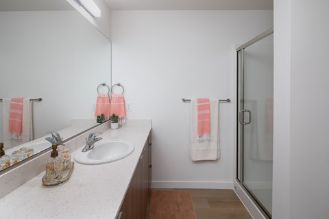 A bathroom with a sink, mirror, and towel hanging on the door at The Arvon, Vancouver, WA 98662