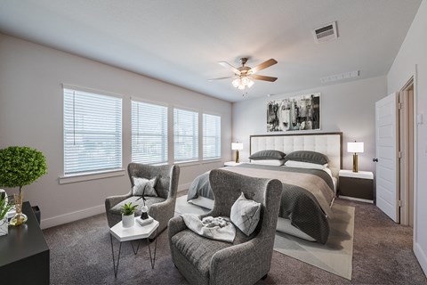 a bedroom with a large bed and a ceiling fan
