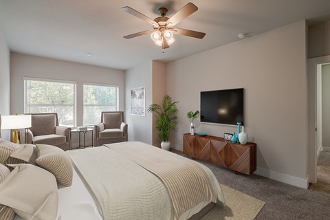 a bedroom with a large bed and a ceiling fan
