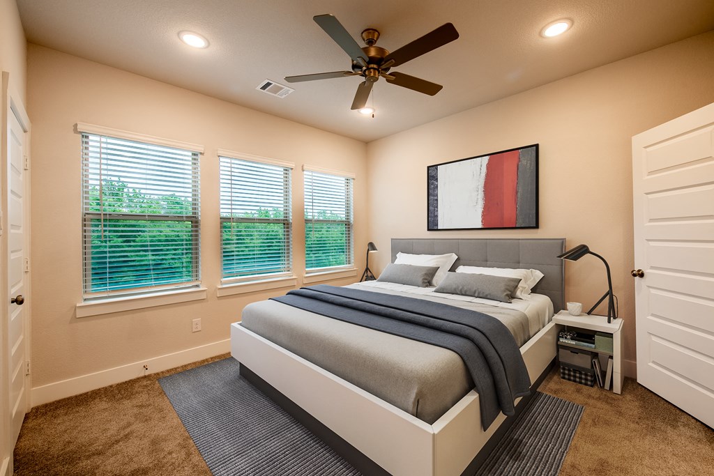 a bedroom with a bed and a ceiling fan