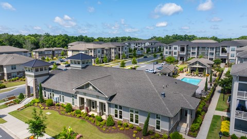 A large house with a pool in the front yard of a residential area.